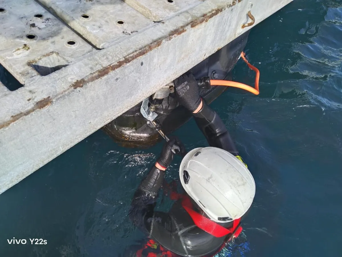 Buzo trabajando en la línea de agua de un módulo